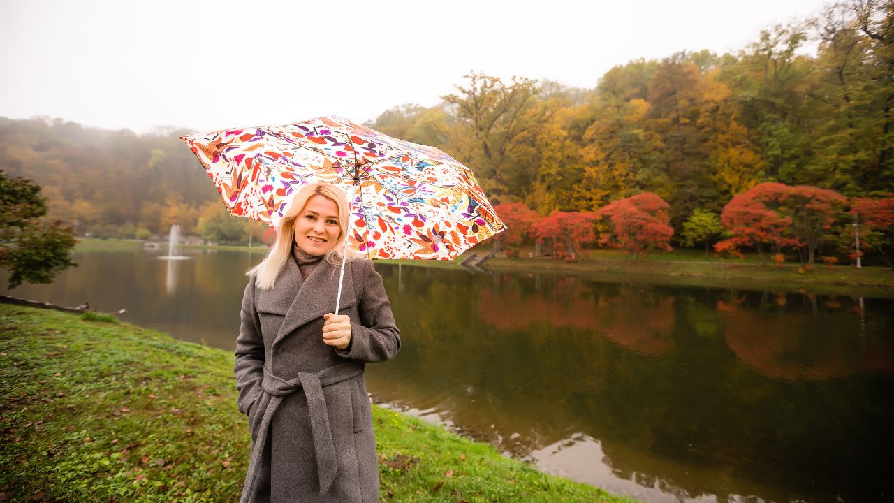 Woman smiling with a colorful umbrella in an autumn park, enjoying nature. Fun and Easy Riddles Every Kid Will Love