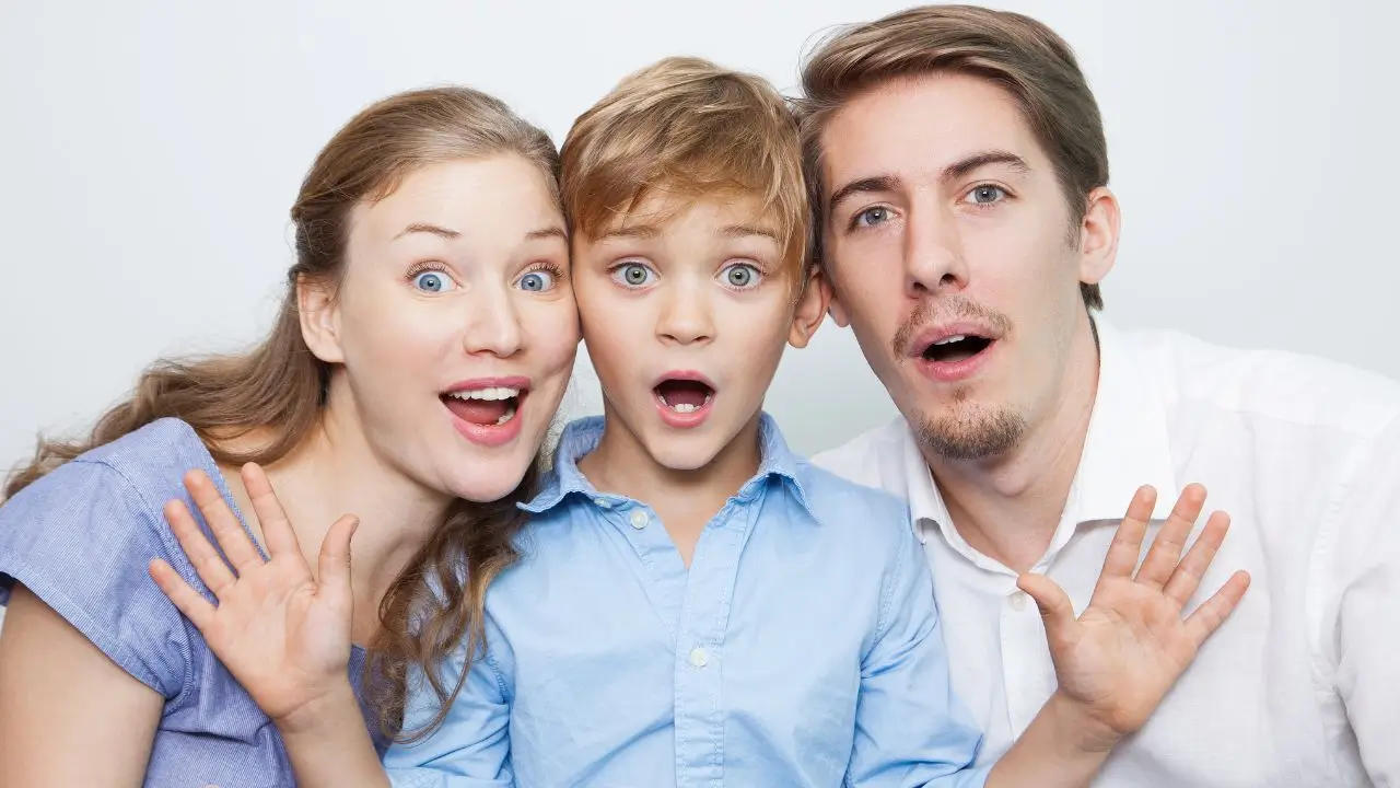 A happy family of three making surprised and funny faces together, enjoying clever and hilarious riddles that make everyone laugh and think. unny riddles for kids and adults alike.