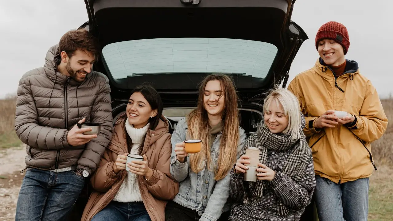 A group of friends enjoying coffee and laughing together during a road trip, capturing the spirit of funny jokes that’ll make you laugh out loud.