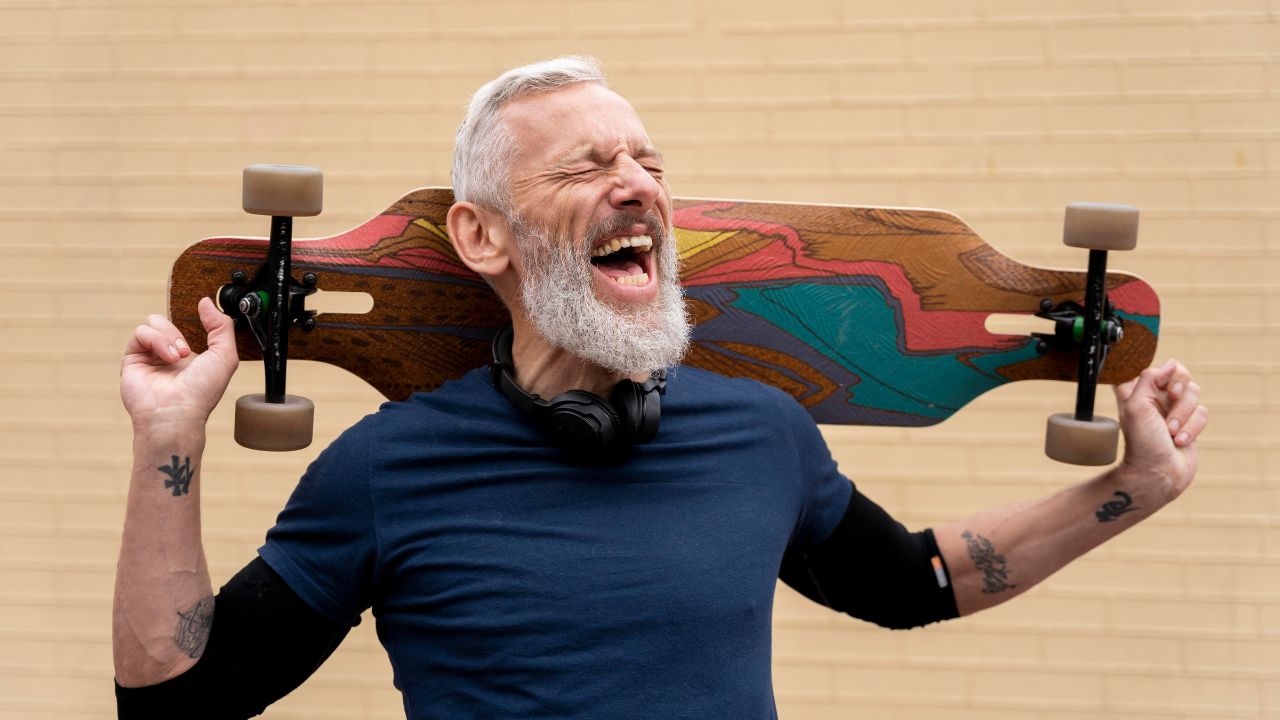 A grandpa with a big beard, laughing joyfully while holding a skateboard over his shoulder. Classic Dad Jokes That Never Get Old