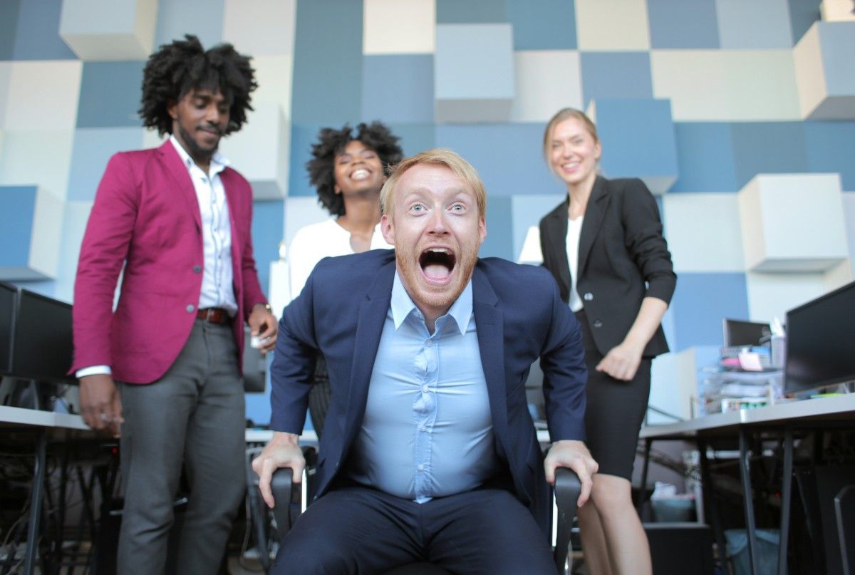 Funny work jokes moment – excited USA office team laughing together. 50+ Funny Work Jokes for the USA Workplace 