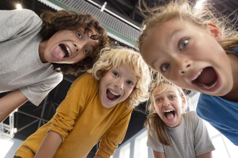 Group of happy children laughing out loud after listening to the best funny jokes