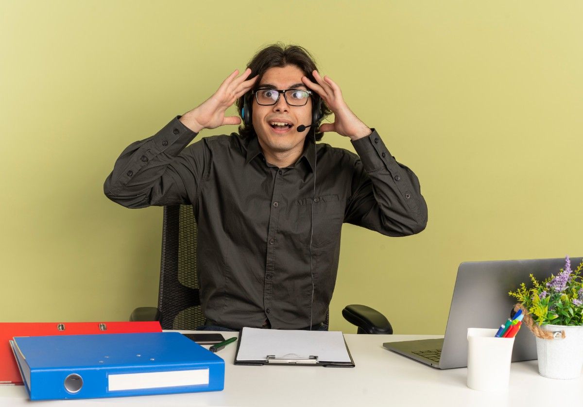 Funny work jokes reaction – surprised office employee with headset at USA workplace. 50+ Funny Work Jokes for the USA Workplace
