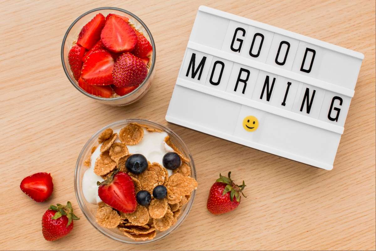 Healthy breakfast with strawberries, cereal, and yogurt beside a “Good Morning” sign.